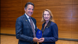 Mitch Mondry, pictured with Dean Sharon Matusik, receives Legacy of Excellence Award at Michigan Ross