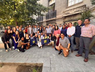 Group photo of Michigan Ross Online MBA students and faculty in Chile holding a Michigan Ross flag. 