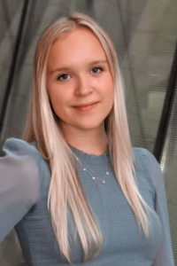 Photo of Elien Michielssen Michigan Ross Weekend MBA student. She is wearing a light blue long sleeve shirt and has long blond hair and she is smiling.