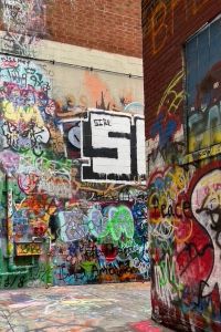 Photo of Graffiti Alley in Ann Arbor with lots of multi-colored artwork on the walls and ground.