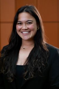 Photo of Michigan Ross Weekend MBA student Katie Manzione who is wearing a black jacket with a black shirt. She has long dark hair and is smiling. 