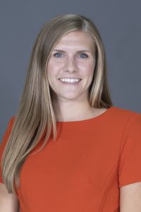 Photo of Julie Kessler Michigan Ross WMBA student with long blond straight hair wearing a red dress and smiling 