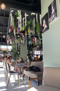 Interior of the Stray Hen restaurant with flowers hanging from the ceiling. 