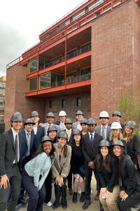 Group of Michigan Ross students wearing hard hats standing outside of a building in New York City. 
