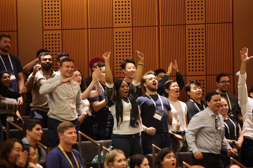 Students shouting, jumping, and cheering in their seats at Robertson Auditorium.