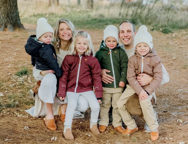 Ruud, her husband, and their four children posing in winter gear outdoors.