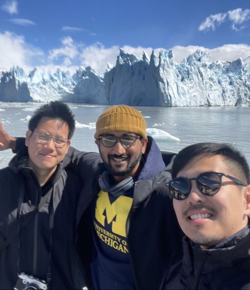 Napat and colleagues in front of water and glaciers.