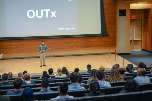 A student presenting on stage at OUTx