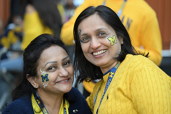 2 people with block M face paint smile for the camera