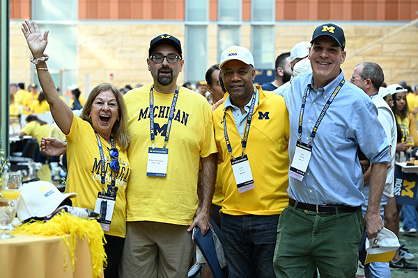 4 people smile and cheer for the camera