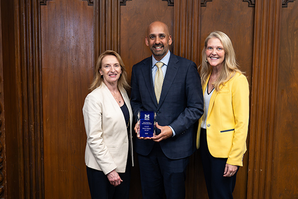 3 people posing with award. One of them is Dean Matusik