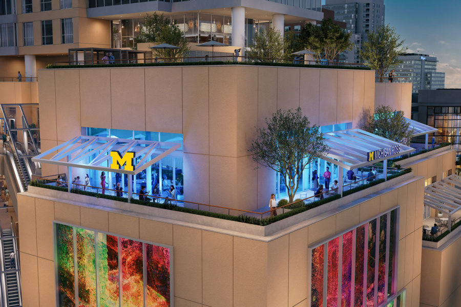 A rooftop event space with a University of Michigan logo on the glass facade.