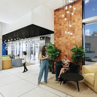 Modern office lobby with people conversing. Features include large windows, hanging lights, wooden accent wall, and cozy seating with a chic ambiance.