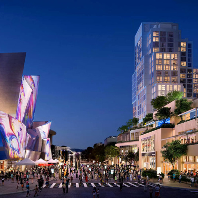 Vibrant cityscape at dusk with illuminated buildings. A modern, reflective structure on the left hosts colorful lights, while bustling crowds engage on the lively street below, conveying an energetic urban atmosphere.