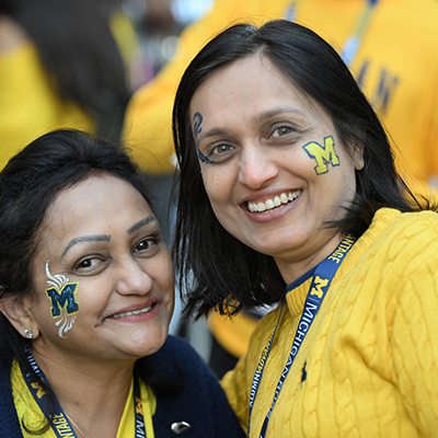 2 people with block M face paint smile for the camera