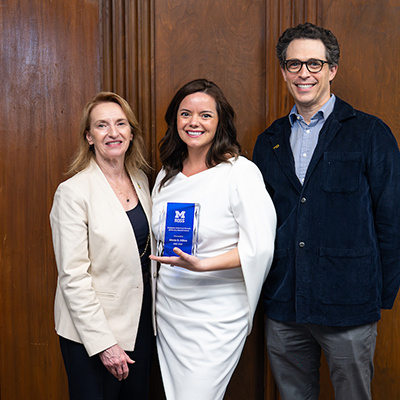 3 people posing with award. One of them is Dean Matusik