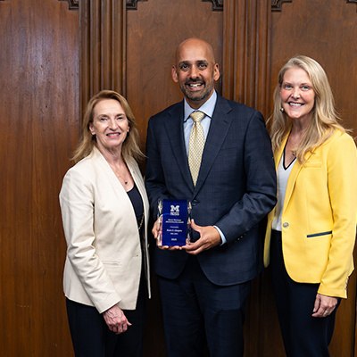 3 people posing with award. One of them is Dean Matusik