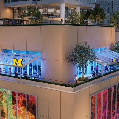 A rooftop event space with a University of Michigan logo on the glass facade.