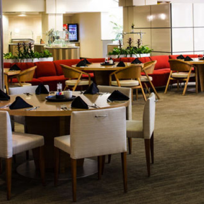 Modern restaurant dining area with neatly set tables and red booth seating.