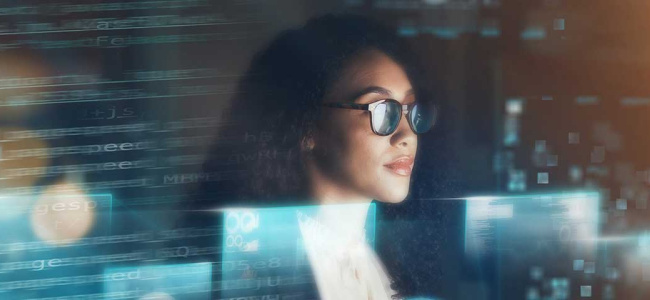 A person is surrounded by glowing computer screens and digital code, creating a high-tech atmosphere.