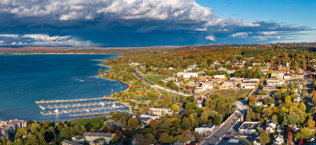 drone shot of Petoskey, Michigan showing lake michigan and a lake town