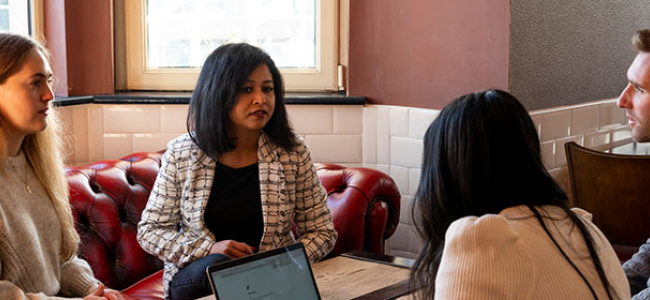 group of people sitting in coffee shop with laptop