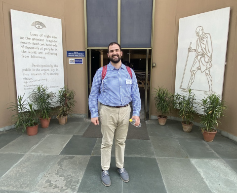 A person with a backpack stands at the entrance of a building with artwork and quote panels.