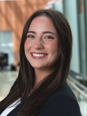 Professional woman smiling in a well-lit indoor setting.