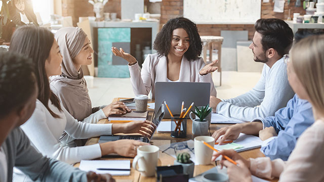 Team members collaborate around a table during a business meeting.