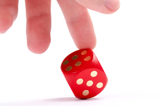 Photo illustration of six-sided die and a hand changing the roll