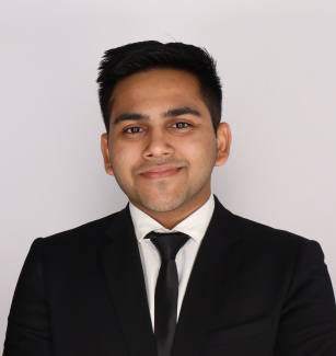 A picture of a person in a suit and off-white background.