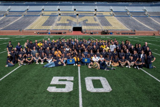 Group of students sitting on a football field. 