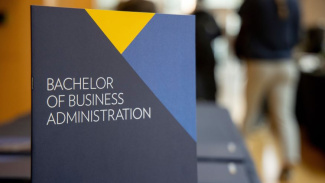 Photo of cover of Business Administration viewbook that is maize and blue. 