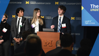 A team presenting at the Leadership Crisis Challenge on stage.