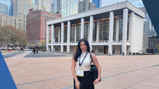 Photo of Lilyan Zebib BBA student standing in front of a building in New York City. 