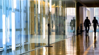 Photo of interior of Ross School of Business building with two students walking through the hallway 