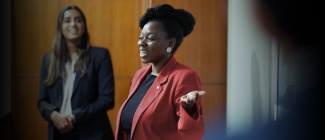 woman pointing at whiteboard, smiling and confident 