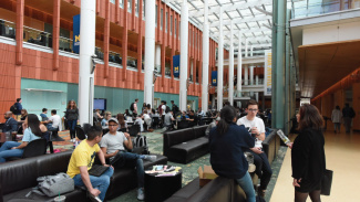 People gathered in Winter Garden hanging out and studying.