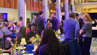Candid shot of people standing and sitting at the 2026 Donors & Scholars Celebration