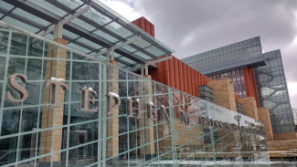 Photo of the outside of the Ross School of Business building with a sign with the full name of the school on it - Stephen M. Ross School of Business. The building has a lot of windows and there is a small bit of snow on top of the letters in the name.