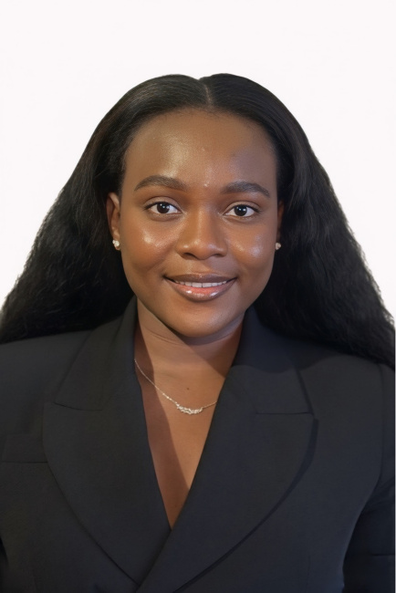 Photo of Kemi Orsile. Person wearing a black blazer and necklace, smiling at the camera against a white background.
