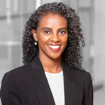Saron Mechale in a black blazer standing in an office setting.