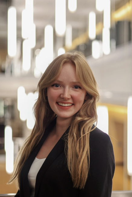 Sara Zubieta in business attire standing indoors with modern, bright lighting in the background.