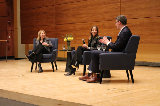 Dean Matusik, Mary Barra, and Mike Hanley sit on stage engaged in a panel discussion.
