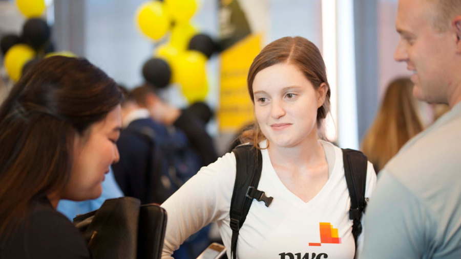 Students in the hallway talking during a recruiting event