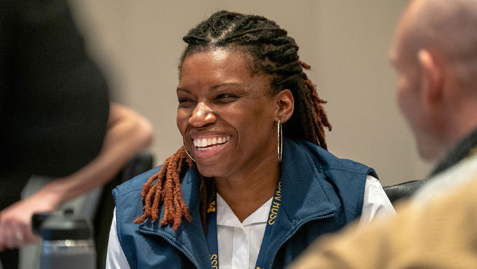 EMBA student, female smiling with white shirt and blue fleece vest on