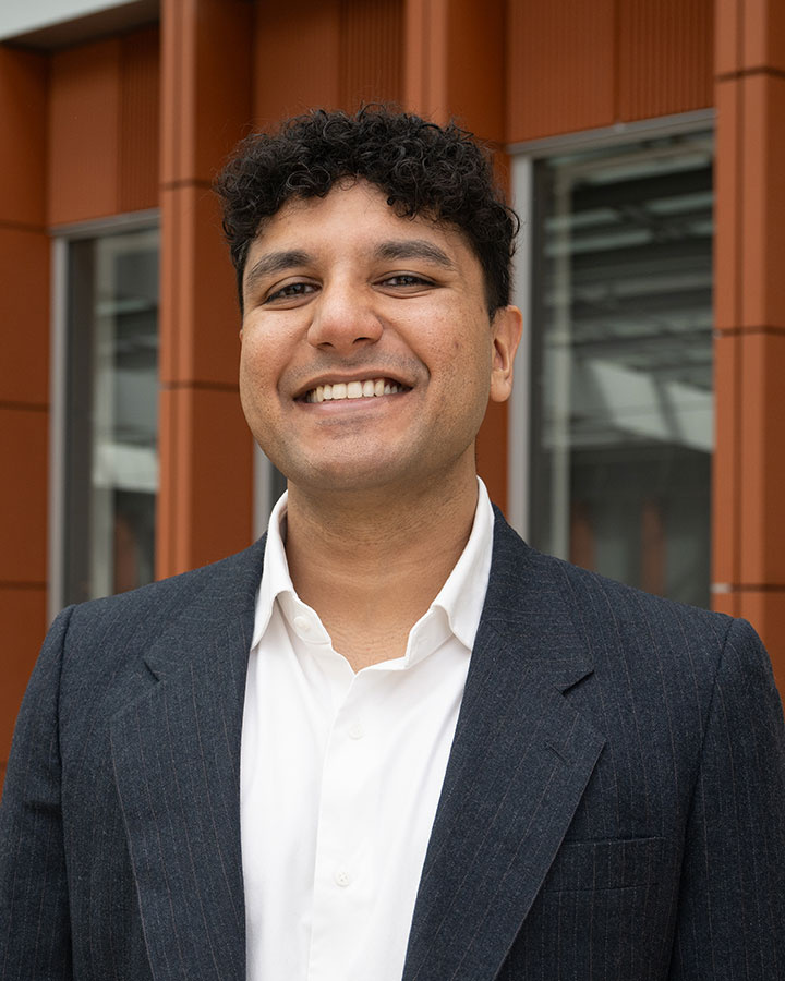 Rahul Narain suit standing in front of a modern building facade.
