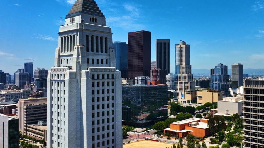 Los Angeles city skyline with the historic City Hall in the foreground on a clear day.