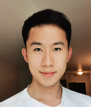 Headshot of a young person with short dark hair wearing a white shirt.