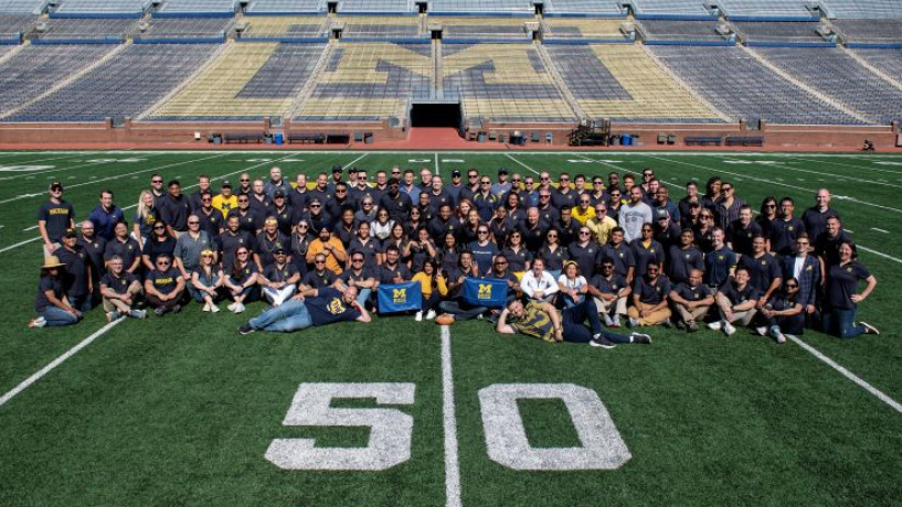 Group of students sitting on a football field. 